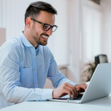 Man in blue shirt using laptop