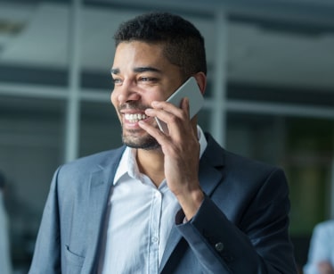Man in grey suit talking over phone